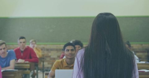 Female Student Presenting in Classroom to Engaged Peers