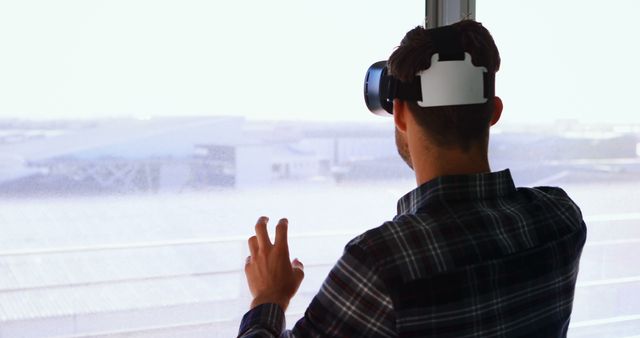 Man Experiencing Virtual Reality with Headset while Standing near Window - Download Free Stock Images Pikwizard.com