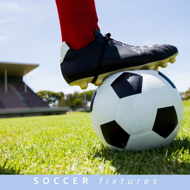 Shows a soccer player stepping on a soccer ball on a grassy field. Ideal for use in promotional materials, websites, or articles related to soccer events, sportswear advertisements, or athletic training.