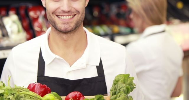 Smiling Grocery Worker Holding Fresh Vegetables in Store - Download Free Stock Images Pikwizard.com