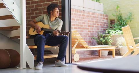 Young Man Enjoying Guitar in Sunny Home Environment