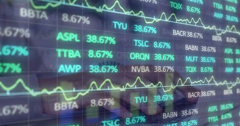 Digital interface and stock market data with blurred hands typing