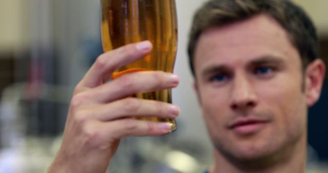 Brewmaster Examining Color and Clarity of Freshly Brewed Beer - Download Free Stock Images Pikwizard.com