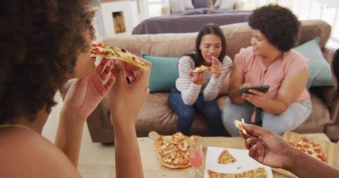 Female Friends Enjoying Pizza in Cozy Living Room