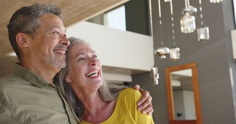 Senior Couple Embracing Joyfully in Modern Living Room