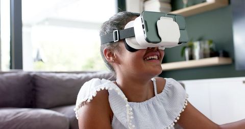 Smiling Girl Engaging with Virtual Reality at Home