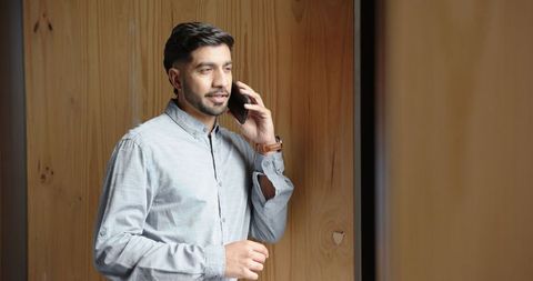 Businessman Talking on Smartphone Checking Wristwatch