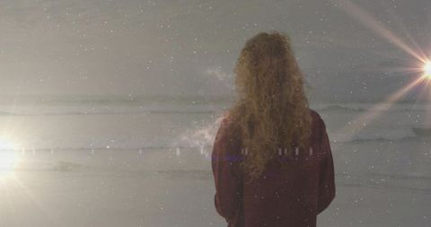 Solitary Woman Standing on Beach at Dusk with Ocean Waves