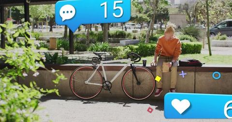 Youth Engaged with Smartphone in Park Next to Bicycle