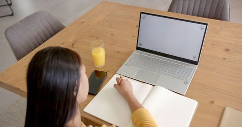Focused Woman Studying With Laptop and Notepad Completing Important Task - Download Free Stock Images Pikwizard.com