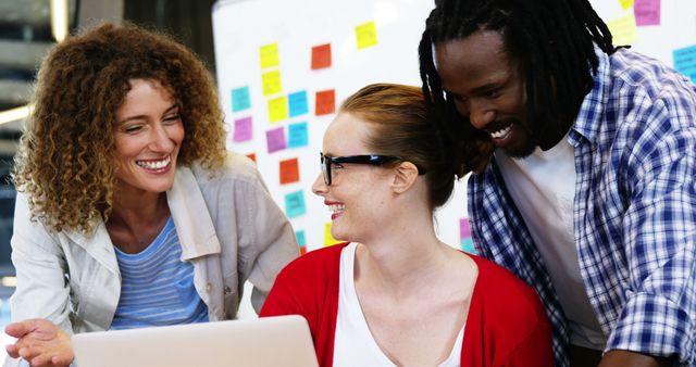 Happy Diverse Coworkers Collaborating on Laptop in Modern Office - Download Free Stock Images Pikwizard.com