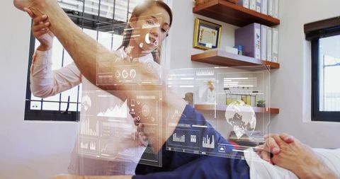 Physical therapist assisting senior patient with leg mobilization using hud interface
