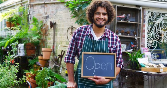 Happy Plant Shop Owner Holding Open Sign in Garden Store - Download Free Stock Images Pikwizard.com