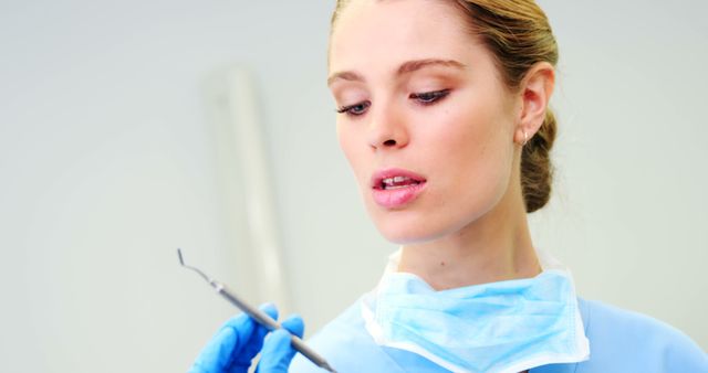 Focused Female Dentist Examining Dental Instrument - Download Free Stock Images Pikwizard.com