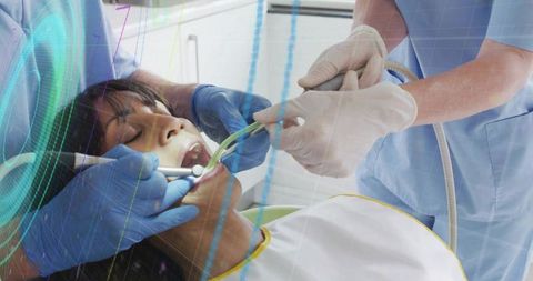 Dental team performing oral exam with suction and mirror in modern clinic operatory