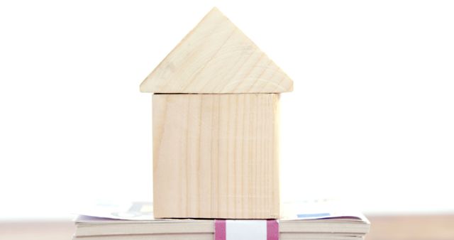 Wooden House Model on Stack of Books with White Background - Download Free Stock Images Pikwizard.com