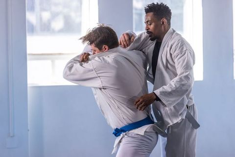 Diverse martial artists training in sport hall encounter