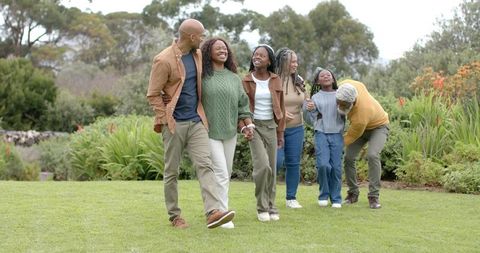 Multigenerational African American Family Walking Together in Garden, Sharing Joy