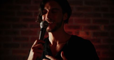Caucasian Artist Singing with Passion Against Brick Wall - Download Free Stock Images Pikwizard.com
