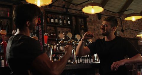 Friends Celebrating with High-Five at Bar Counter - Download Free Stock Images Pikwizard.com