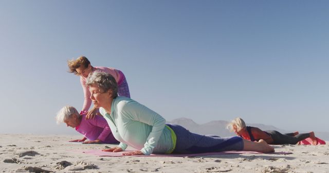 Diverse women with female yoga instructor wearing sports clothes doing yoga and stretching at beach - Download Free Stock Photos Pikwizard.com