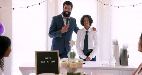 Father and Son Celebrating Bar Mitzvah with Speech and Decorations