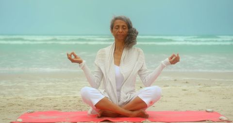 Serene Senior Woman Meditating on Beach in Lotus Pose - Download Free Stock Images Pikwizard.com