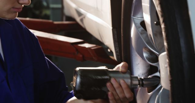 Mechanic Using Power Tool to Repair Car Wheel in Garage - Download Free Stock Images Pikwizard.com