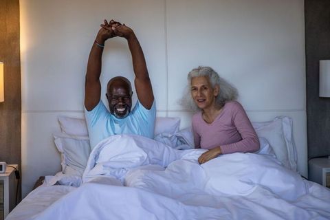 Senior Couple Enjoying Morning Stretching in Cozy Bedroom