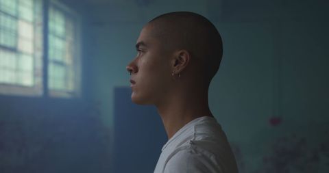 Contemplative Young Man in Dimly Lit Room - Download Free Stock Images Pikwizard.com