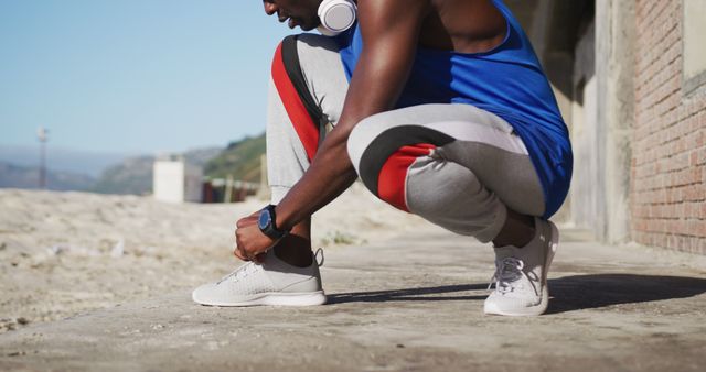 Male Athlete Tying Shoes Outdoors for Fitness Routine - Download Free Stock Images Pikwizard.com