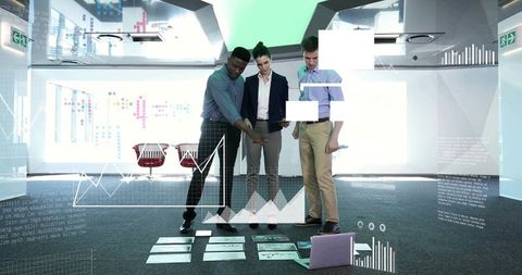 Collaborating team analyzing data visualizations on office floor with tablet overlays