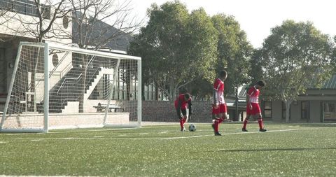 Youth Soccer Players on Green Field Sporting Red Uniforms