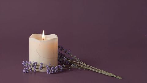 Ivory pillar candle with lavender on plum background