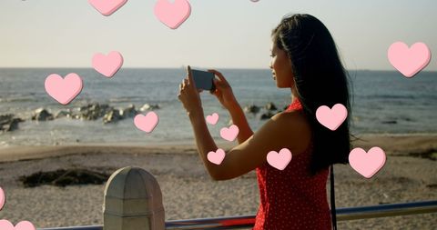 Woman Capturing Coastal View Against Heart Graphic Overlay - Download Free Stock Images Pikwizard.com