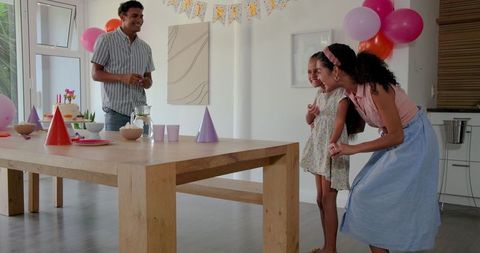 Family celebrating in decorated home with birthday setup