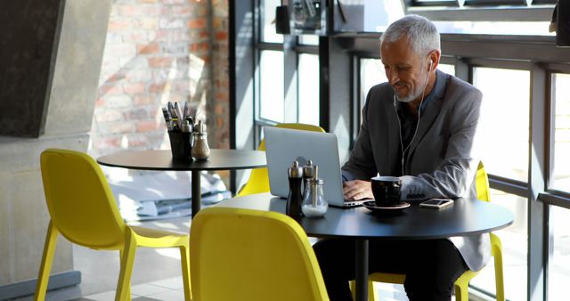 Businessman Working on Laptop in Trendy Café - Download Free Stock Images Pikwizard.com