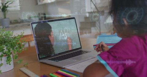 Child studying at kitchen table with laptop tutor teaching chalkboard letters remote learning