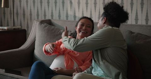 Happy couple planning wedding at home on couch