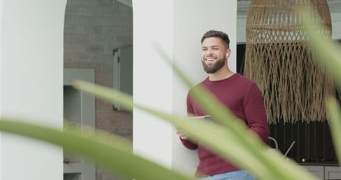Bearded man with tablet relaxing on terrace