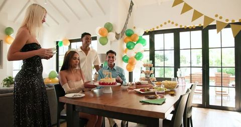 Enjoying Birthday Celebration with Friends in Sunny Living Room