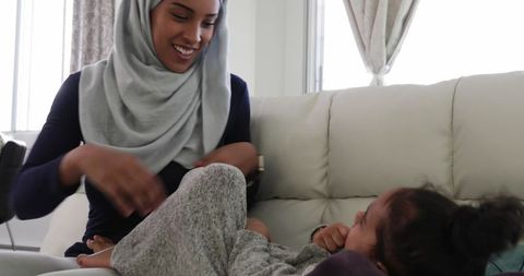 Joyful mother daughters bonding closeup sofa home