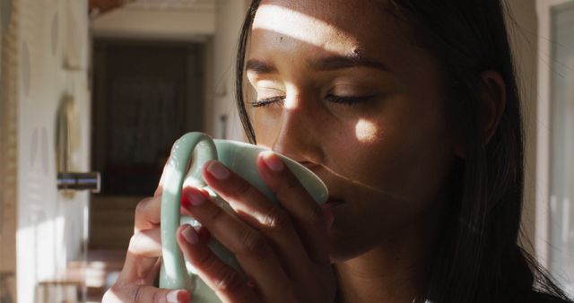 Woman Savoring Warm Beverage in Sunlit Room - Download Free Stock Images Pikwizard.com