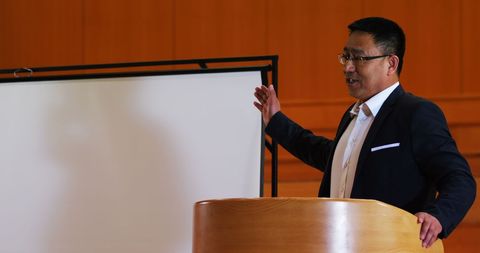 Businessman Delivering Engaging Speech at Conference Center Podium