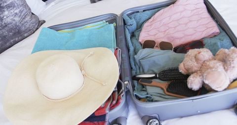 Open Suitcase Packed for Vacation with Clothes and Accessories