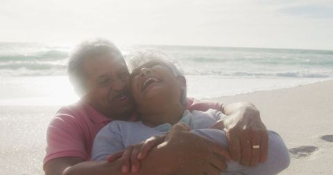 Happy Senior Couple Embracing at Sunlit Beach