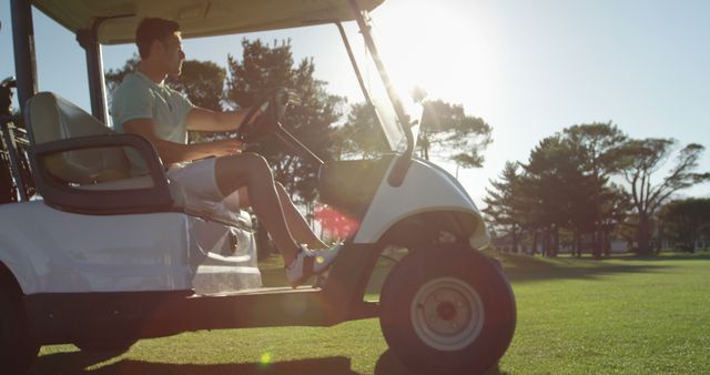 Golfer driving in his golf buggy at golf course