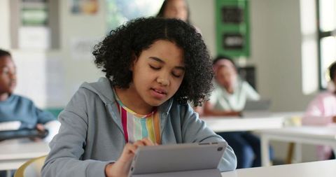 African American girl using tablet in classroom learning with technology focused student