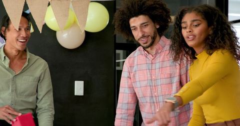 Diverse team decorating for office baby shower celebration