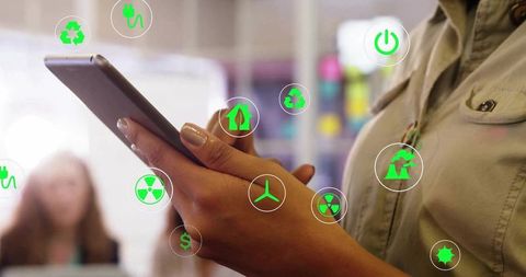 Businesswoman Using Tablet Surrounded by Green Energy Icons